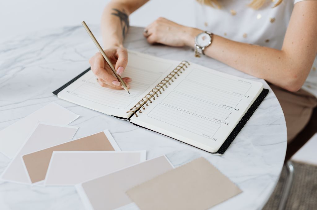 A woman writing in a gratitude journal as part of her new year's goal ideas