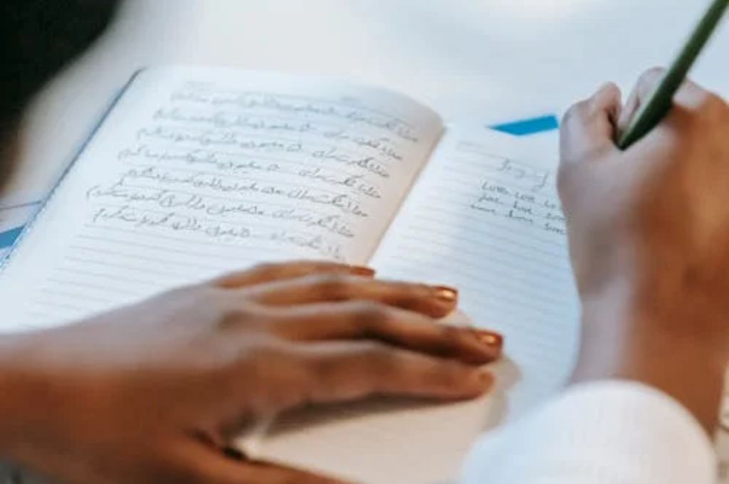 Woman writing in her notebook using Journaling Prompts for Anxiety