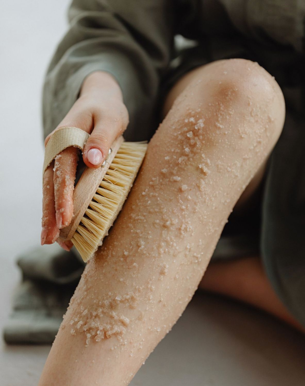 woman exfoliating her skin as a glow up tip